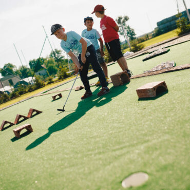 Dzieci grające w minigolfa na obozie w folwarku matecznik