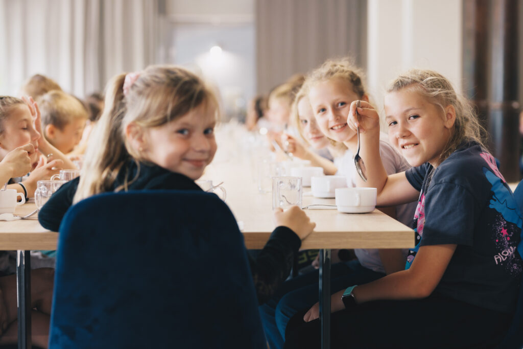 dzieci jedzące obiad na zielonej szkole